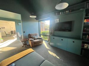 un soggiorno con divano e TV di Luxury Lake View House a Lake Tekapo