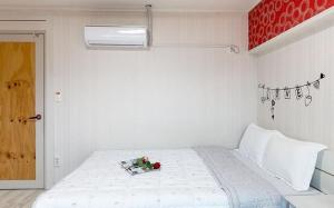 a bedroom with a white bed with flowers on it at Sunbeach Pension in Geoje 
