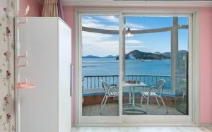 a view of the ocean from a balcony with a table and chairs at Sunbeach Pension in Geoje 