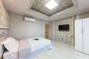 a bedroom with a bed and a flat screen tv at Sunbeach Pension in Geoje 