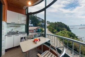 a kitchen with a table and a view of the ocean at Sunbeach Pension in Geoje 