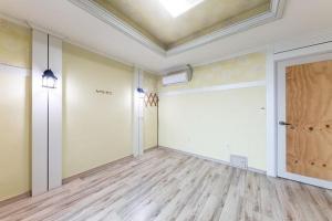 an empty room with a wooden floor and a door at Sunbeach Pension in Geoje 