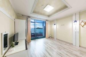 a large room with a view of the ocean at Sunbeach Pension in Geoje 