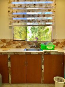 una cucina con lavandino e una finestra con un mucchio di scarpe di Cozy mountain house a Urubamba
