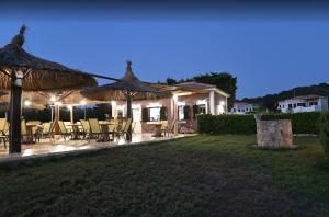 a patio with tables and chairs and umbrellas at night at Anastasia Villas in Kástro Tornéze