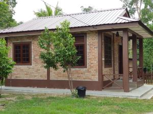 a small brick house with a metal roof at D'Impiana Riverview Chalet # Lenggong in Kampong Ulu Jepai