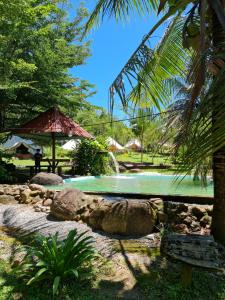 a swimming pool with a waterfall in a park at D'Impiana Riverview Chalet # Lenggong in Kampong Ulu Jepai