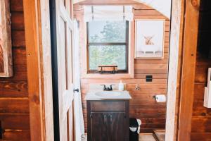 a bathroom with a sink and a window at Heated & AC Full Bathroom Covered Wagon in Penn Yan