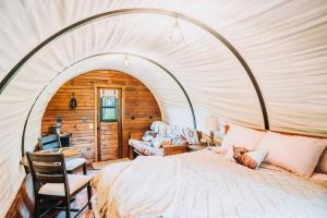 ein Schlafzimmer mit einem großen Bett in einem Zelt in der Unterkunft Heated & AC Full Bathroom Covered Wagon in Penn Yan