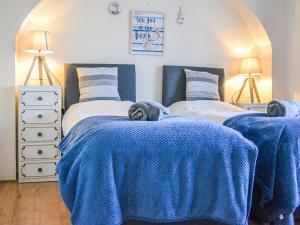 1 dormitorio con 2 camas y mantas azules en Botany Bay Bungalow, en Kingsgate