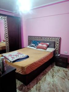 uma cama com duas almofadas num quarto em شقه مفروشه مكيفه نضيفه للايجار علي جسر السويس no Cairo