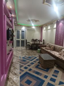 uma sala de estar com um sofá e uma mesa em شقه مفروشه مكيفه نضيفه للايجار علي جسر السويس no Cairo