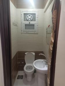 uma pequena casa de banho com WC e lavatório em شقه مفروشه مكيفه نضيفه للايجار علي جسر السويس no Cairo