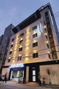 Daon Hotel Gimhae Injae في Gimhae: مبنى الفندق فيه ناس تمشي امامه