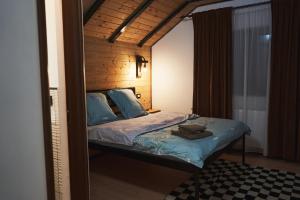 een slaapkamer met een bed met blauwe lakens en blauwe kussens bij Cabana Vasc in Borsa