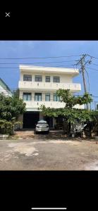 a white building with a car parked in front of it at HOMESTAY HƯƠNG in Vung Tau