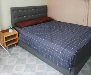 Schlafzimmer mit einem Bett mit blauer Decke in der Unterkunft JATUPORN A2 in Ban Talat Rangsit