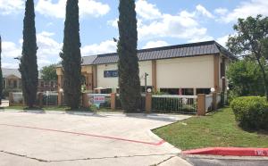 a building with palm trees in front of it at Coratel Inn & Suites by Jasper New Braunfels IH-35 EXT 189 in New Braunfels