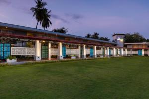 un edificio con un campo verde delante de él en Elephyard Retreat en Mahiyangana