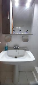 a bathroom with a white sink and a mirror at Tranquility Base in Neapoli Voion