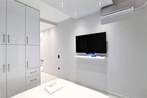 a white room with a flat screen tv on a wall at Unique Lodging in Athens