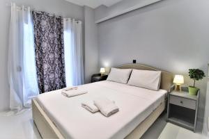 ein Schlafzimmer mit einem weißen Bett mit zwei Handtüchern darauf in der Unterkunft Unique Lodging in Athen