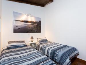 duas camas num quarto com uma fotografia na parede em Villa Los Silos, 4 dormitorios, 8 personas - ES-279-6 em Los Silos