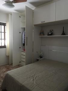 a bedroom with a large bed and white cabinets at Casa Piratininga Niterói Rj in Niterói