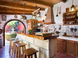 a kitchen with a stone counter and wooden stools at Villa Los Silos, 4 dormitorios, 8 personas - ES-279-6 in Los Silos