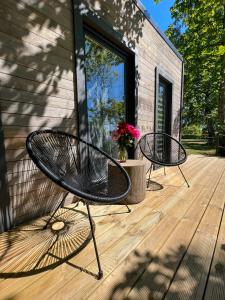 zwei Bänke auf einer Holzterrasse in der Unterkunft DuneHouse in Tūja