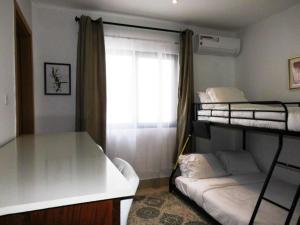 sypialnia z 2 łóżkami piętrowymi i oknem w obiekcie Luxury & Comfort, with Pool and Ocean Views w mieście Bijilo