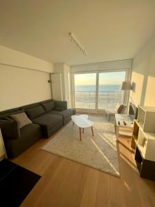 - un salon avec un canapé et une table dans l'établissement Zeedijk family apartment, à Knokke-Heist