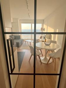 uma vista para uma sala de estar com uma mesa e cadeiras em Zeedijk family apartment em Knokke-Heist