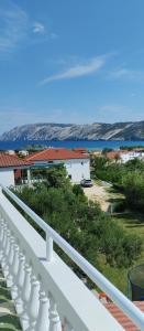 a white balcony with a view of the ocean at Apartmani Gero in Lopar