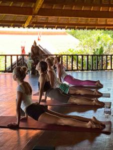 un grupo de mujeres sentadas en el suelo en una clase de yoga en Udara Bali Yoga Detox & Spa, en Canggu