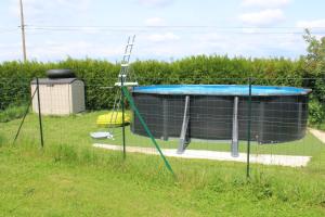 a trampoline in the grass next to a trampoline at Gite LA ROCHERIE in Hambers