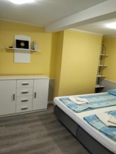 a bedroom with a bed and a yellow wall at Levendulás Ház in Hajdúszoboszló