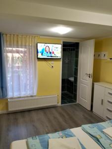 ハイドゥソボスローにあるLevendulás Házのベッドルーム1室(壁にテレビ付)、バスルーム1室が備わります。