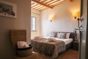 ein Schlafzimmer mit einem Bett und einem Stuhl in einem Zimmer in der Unterkunft Boutique Hotel Casa Grimaldi in Matelica