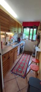 - une cuisine avec des placards en bois et un tapis au sol dans l'établissement Cottage in traditional village Bradulet, Arges county, à Brăduleţ