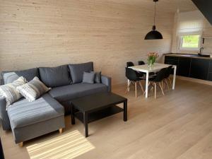 uma sala de estar com um sofá e uma mesa em PoProstuDomki em Niechorze