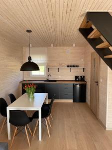 尼可薩茲的住宿－PoProstuDomki，厨房以及带白色桌椅的用餐室。
