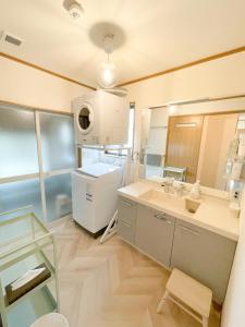 ein großes Bad mit einem Waschbecken und einem Spiegel in der Unterkunft Izu Serenity Fuji-View Retreat with Private Onsen in Izu