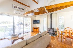 - un salon avec un canapé, une table et une cheminée dans l'établissement Beach Shack on the Lagoon, à Berrara