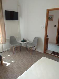 a room with two chairs and a table and a tv at Park Nyaralóház in Badacsonytomaj