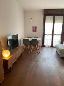 - un salon avec une télévision, une table et des chaises dans l'établissement B&B Campi di sole, à Sala Bolognese