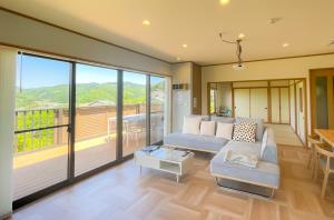 a living room with a couch and a balcony at Izu Serenity Fuji-View Retreat with Private Onsen in Izu