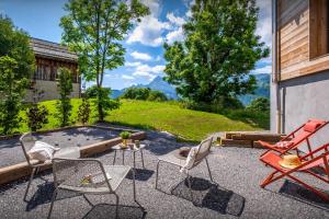 a patio with chairs and a table and a fire pit at Chalet Mevi - OVO Network in Crest-Voland