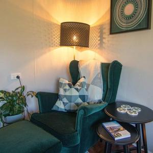 una sala de estar con una silla verde y una mesa en Banksia Cottage, pretty cottage with garden, en Leura