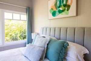 1 dormitorio con 1 cama y ventana grande en Banksia Cottage, pretty cottage with garden, en Leura